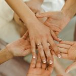 Group of women showcasing an engagement ring, capturing a special moment.